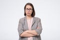 Skeptical mature woman in glasses wearing formal clothes looking suspicious. She does not trust her coworker Royalty Free Stock Photo