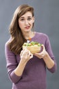 Skeptical 20s girl questioning the taste of a mixed green salad Royalty Free Stock Photo