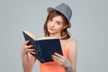 Skeptical woman holding a book looking at you camera skeptically Royalty Free Stock Photo