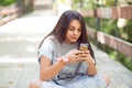 Skeptical woman texting in park Royalty Free Stock Photo