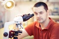 Skeptical Young Male Researcher with microscope