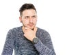 skeptical young modern brunette man with clock and hand an chin looks thoughtful into the future - isolated in white background