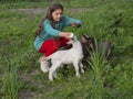 A sketch from real life. A girl feeds small goats with milk from a bottle