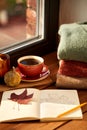 sketchbook, autumn leaf and coffee on window sill