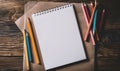 A sketchbook open to a blank page with graphite pencils beside it Royalty Free Stock Photo