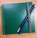 A sketchbook with a pair of drawing pencils