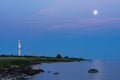 Evening sunlight on coast, pink clouds, blue sky reflection on water. Beach in summer. Seaside natural environment. Royalty Free Stock Photo