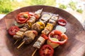 Skewered meat prepared on grill with vegetables. Barbecued shish kebab or shashlik on sticks Royalty Free Stock Photo