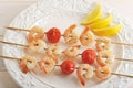 Skewered shrimp with cherry tomatoes on wooden skewers and lemon Royalty Free Stock Photo