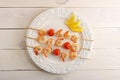 Skewered shrimp with cherry tomatoes on wooden skewers and lemon Royalty Free Stock Photo