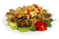 Skewers of chicken, pork, beef, lamb with greens on the plate, isolated Royalty Free Stock Photo