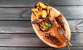 Skewers of Meat with sauce and potatoes fries in a bucket on wooden cutting board Royalty Free Stock Photo