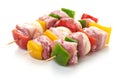Skewers with pieces of raw meat, red, yellow and green bell pepper, seasoned with coarse salt and olive oil, isolated on white Royalty Free Stock Photo