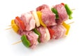 Skewers with pieces of raw meat, red, yellow and green bell pepper, seasoned with coarse salt and olive oil, isolated on white Royalty Free Stock Photo