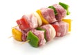 Skewers with pieces of raw meat, red, yellow and green bell pepper, seasoned with coarse salt and olive oil, isolated on white Royalty Free Stock Photo