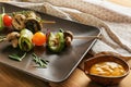 Skewers with tasty grilled vegetables and sauce on wooden table Royalty Free Stock Photo