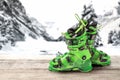 Ski boots on a wooden table against the background of mountains. bright green sports ski boots Royalty Free Stock Photo