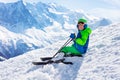 Ski boy sit on snow with mountain peak background Royalty Free Stock Photo