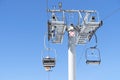 Ski chair lift over blue sky. Ski lift empty ropeway on hilghland mountain winter. Ski chairlift cable way with people enjoy Royalty Free Stock Photo