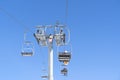 Ski chair lift over blue sky. Ski lift empty ropeway on hilghland mountain winter. Ski chairlift cable way with people enjoy Royalty Free Stock Photo