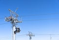Ski chair lift over blue sky. Ski lift empty ropeway on hilghland mountain winter. Ski chairlift cable way with people enjoy Royalty Free Stock Photo
