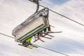 Four skiers on a chair lift against the blue sky, seen from below, from the ski slope. Ski resort Schladming Dachstein, Styria, Au