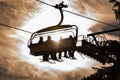 Four skiers on a chair lift against the backdrop of the sun, contour photo, orange shades, ski region Schladming Dachstein Austria