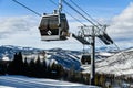 Ski gondola lift with mountains on background.