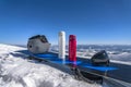 Ski helmet, two thermo bottles and ski goggle on snowboard on snowy mountain top