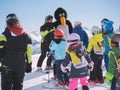 Ski instructor in penguin suit studies young skiers. Ski resort