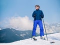 Ski instructor young man on the top of snow hill