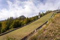 Ski jump hill in front of a mountain and green autumn fall forest in Julijske Alpe Alpi Giulie Alps, Slovenia Slovenija