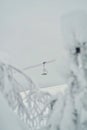 Ski lift or chairlift pictured through the snow-covered trees. Empty chairlift going up the slope, no people. Beautiful snowy Royalty Free Stock Photo