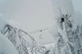 Ski lift or chairlift pictured through the snow-covered trees. Empty chairlift going up the slope, no people. Beautiful snowy Royalty Free Stock Photo