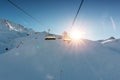 Ski lift empty ropeway on hilghland alpine mountain winter resort on bright sunny evening . Ski chairlift cable way with Royalty Free Stock Photo