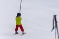 A ski lift pulls a person uphill skiing and snow