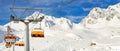Ski lift ropeway on hilghland alpine mountain winter resort on bright sunny day. Ski chairlift cable way with people Royalty Free Stock Photo