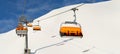 Ski lift ropeway on hilghland alpine mountain winter resort on bright sunny day. Ski chairlift cable way with people Royalty Free Stock Photo