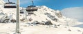 Ski lift ropeway on hilghland alpine mountain winter resort on bright sunny day. Ski chairlift cable way with people Royalty Free Stock Photo