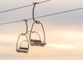 Ski lift with seats going over the snow mountain in ski resort when sunset Royalty Free Stock Photo