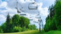 Ski lift in the summer against the blue sky. Deserted ski complex during the off-season. The chair lift with empty cabins does not Royalty Free Stock Photo