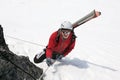 Ski mountaineer climbing on rope on rocky mountain