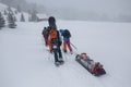 Ski rescuers pull a special sled akya in the mountains with the victim in the middle
