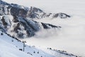 Ski resort in Cloudy Tian Shan mountains in the mist. Ski lift on the slope Royalty Free Stock Photo