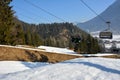 At a ski resort, skiers go up on a lift against the background of mountains and trees Royalty Free Stock Photo