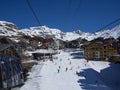 Ski slope and chairlift in Val Thorens, people skiing in the middle of the village