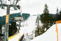 Ski slope with lift on the background of evergreen Carpathian forest, Bukovel resort, Carpathians, Ukraine