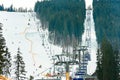 Ski slope with lift on the background of evergreen Carpathian forest, Bukovel resort, Carpathians, Ukraine