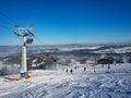 Ski slope with skiers, snowboarders and chairlift