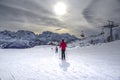 Ski slopes with skiers at sunset. Trentino, Italy